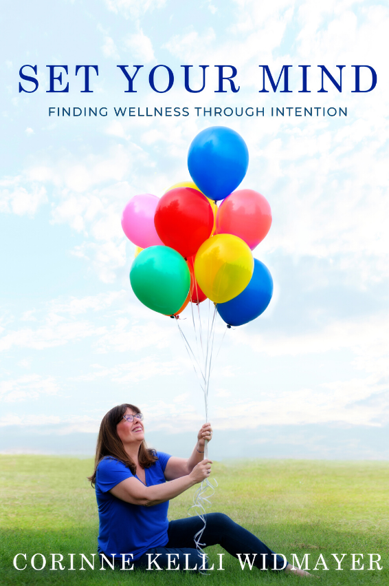 Set Your Mind: Finding Wellness Through Intention. Book cover with woman sitting in grass holding red, yellow, blue, and green balloons.